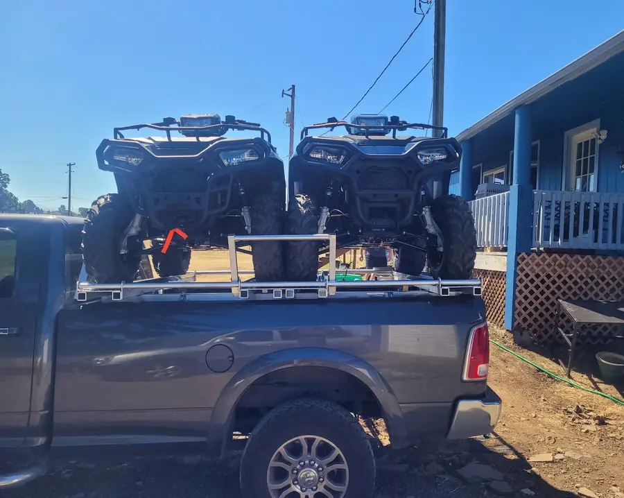 Two ATVs on a custom aluminum rack over a pickup bed