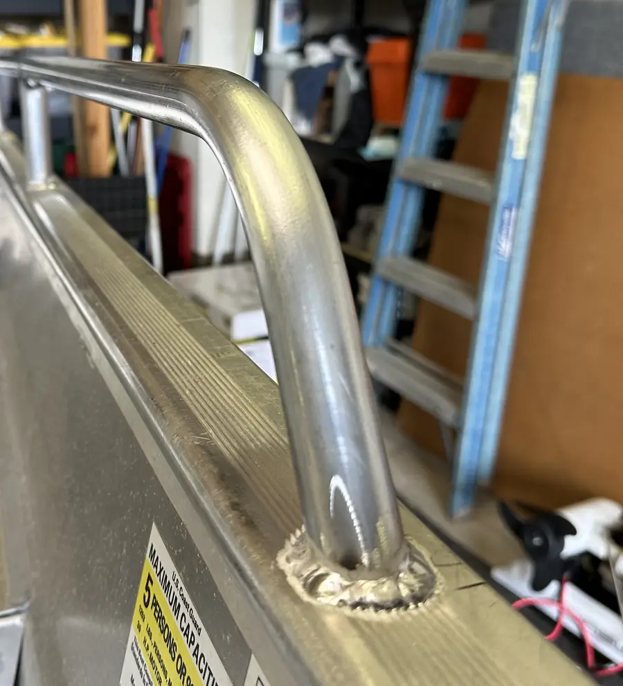 Close-up of the weld where an aluminum grab rail meets the boat's gunwale