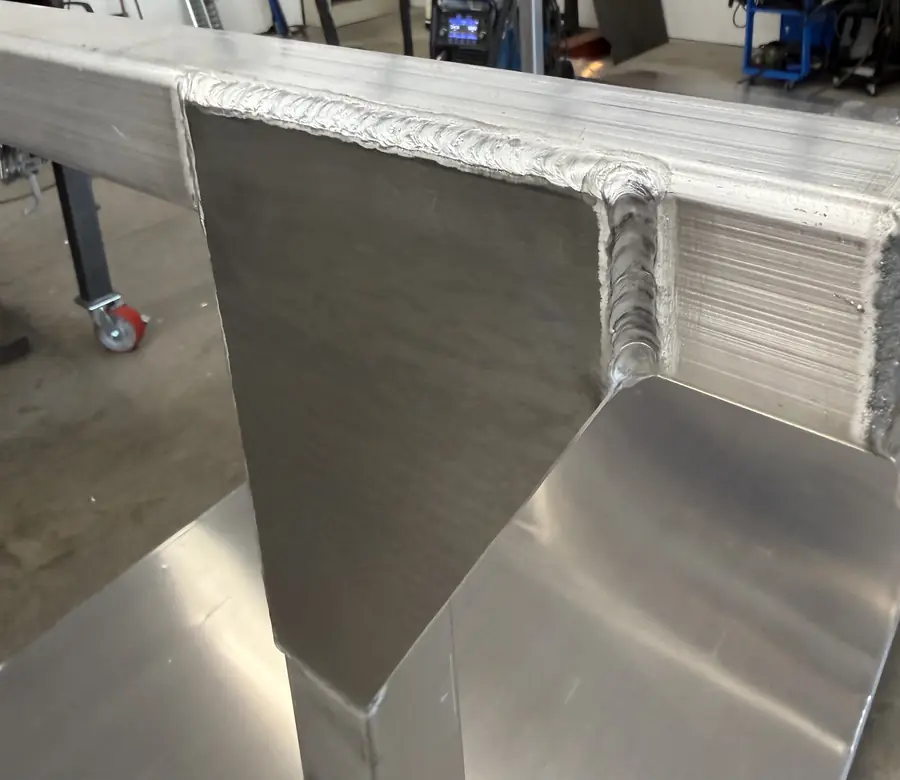 Close-up of a TIG weld bead along an aluminum gusset