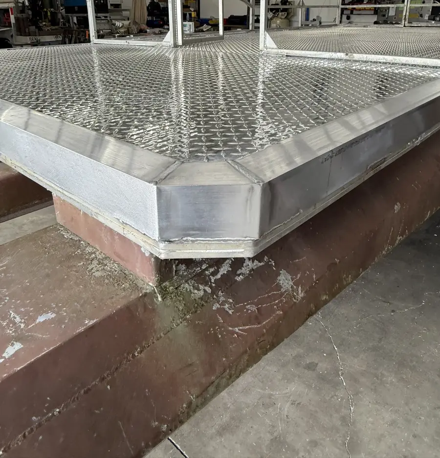 Close-up of the aluminum trim around the corner of a new diamond-plate pontoon deck